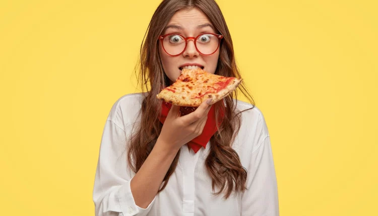 Menina comendo pizza.