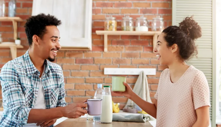 Casal sorrindo na mesa.