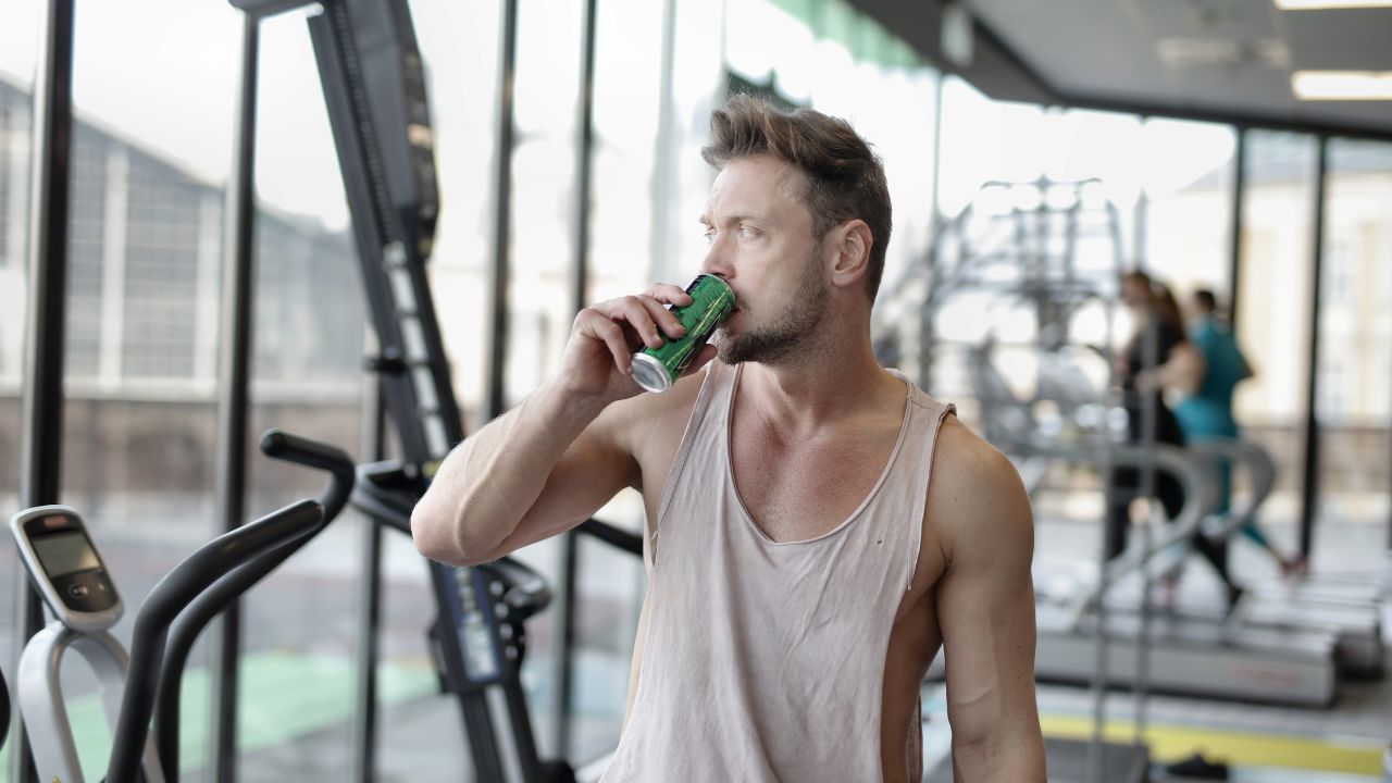 Energéticos naturais. Homem na academia tomando energético.