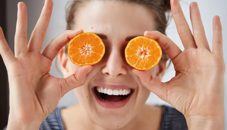 Mulher com fatias de laranja nos olhos.