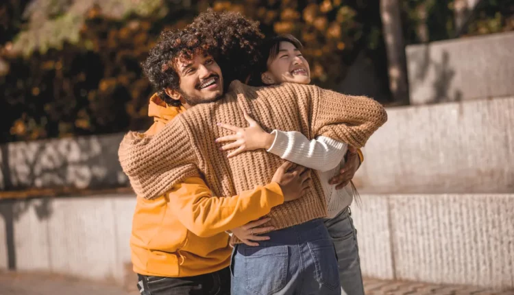 Três amigos se abraçando.